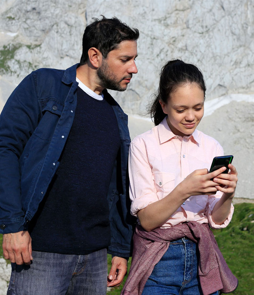 dad watching smartphone of daughter